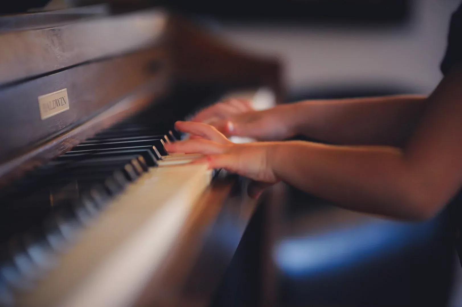 Child's hands on upright piano keys
