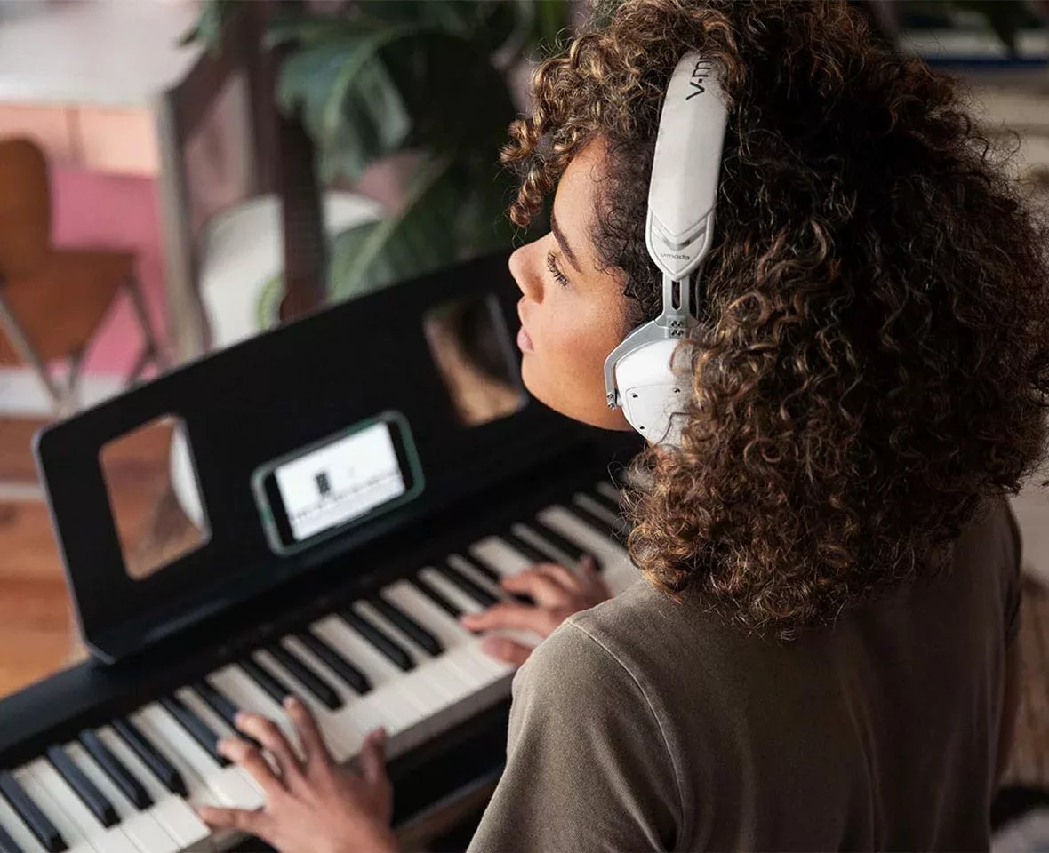 woman playing roland fp-10 with headphones