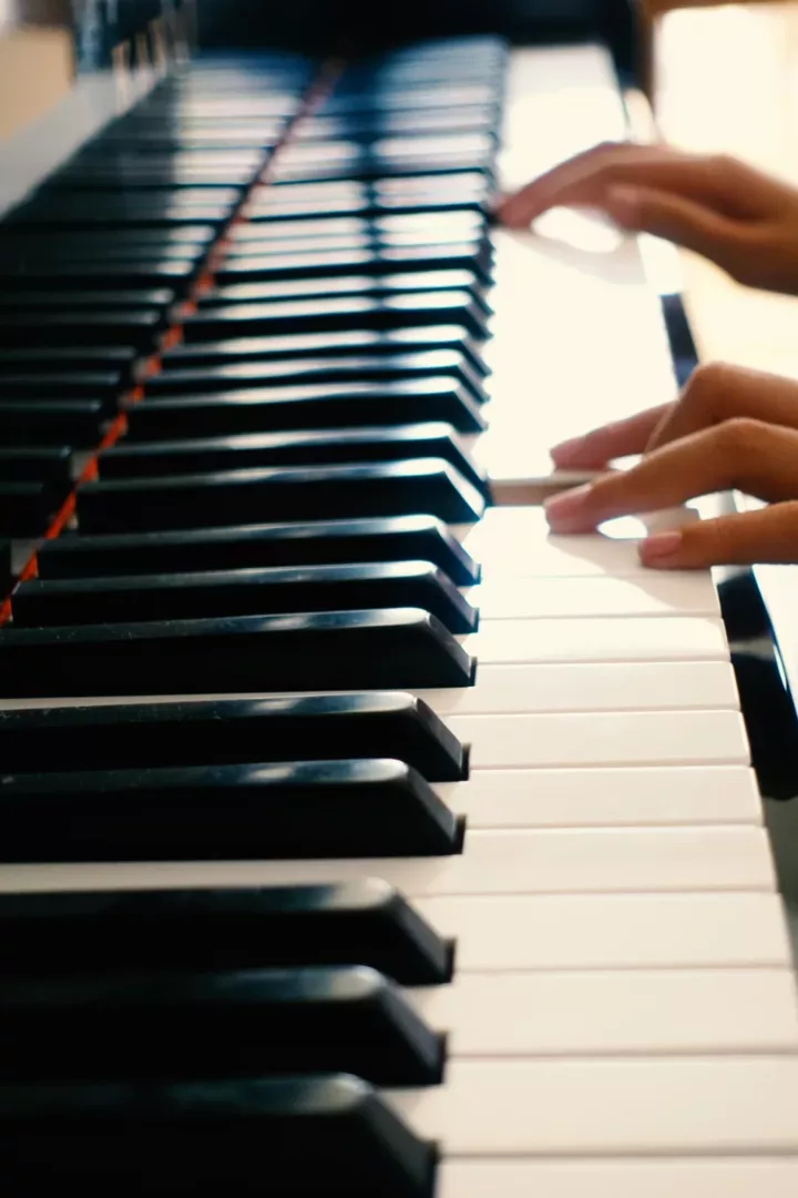 fingers depressing piano keys